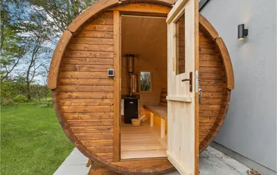 a wooden hobbit house with a wooden door at Awesome Home In Nibe With Kitchen in Nibe