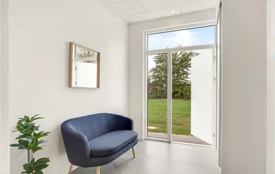 a blue chair in a room with a window at Awesome Home In Nibe With Kitchen in Nibe