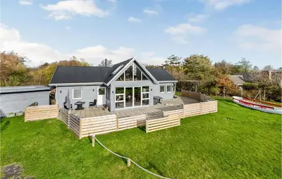 a house with a large deck and a boat at 3 Bedroom Beautiful Home In Vemb in Vemb