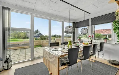 a dining room with a table and chairs and large windows at 3 Bedroom Beautiful Home In Vemb in Vemb