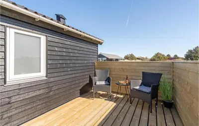 a wooden deck with two chairs and a table at Lovely Home In Thisted With Wifi in Thisted