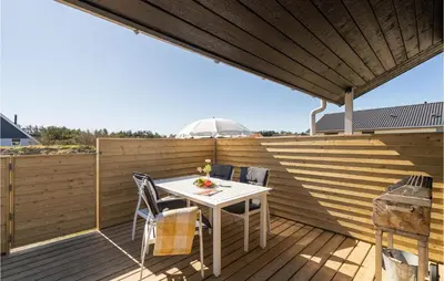 a patio with a table and chairs on a wooden deck at Lovely Home In Thisted With Wifi in Thisted