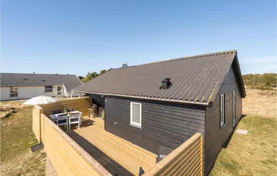 a small black house with a wooden deck at Lovely Home In Thisted With Wifi in Thisted