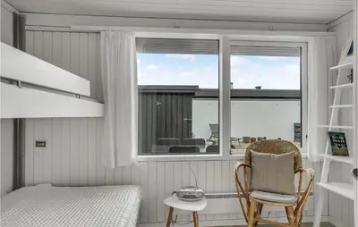 a bedroom with a bed and a window and a chair at Awesome Home In Pandrup With Wifi in Pandrup