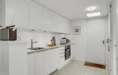 a white kitchen with a sink and a microwave at Awesome Home In Pandrup With Wifi in Pandrup