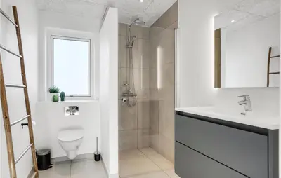 a bathroom with a toilet and a sink and a shower at Nice Home In Blokhus With Sauna in Blokhus