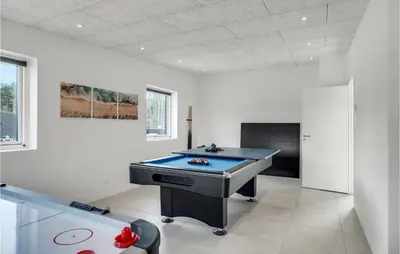 a ping pong table in a room with a pool table at Nice Home In Blokhus With Sauna in Blokhus