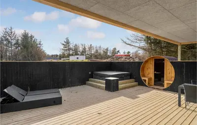 a wooden deck with a wooden door and a building at Nice Home In Blokhus With Sauna in Blokhus