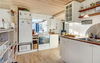 a kitchen with white appliances and a wooden ceiling at 1 Bedroom Lovely Home In Løgstør in Løgstør