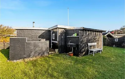 a small shed with a chair in a yard at 1 Bedroom Lovely Home In Løgstør in Løgstør