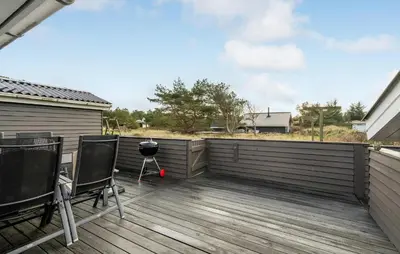 a deck with a grill and chairs on it at Amazing Home In Thisted With Sauna in Thisted