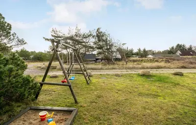 a swing set in a field with a tree at Amazing Home In Thisted With Sauna in Thisted