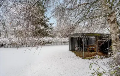 a cage in the snow with a bike in it at 2 Bedroom Awesome Home In Thyholm in Thyholm