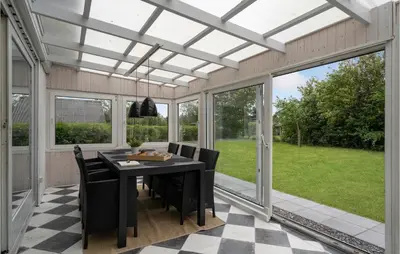 a screened in porch with a black table and chairs at Stunning Home In Vemb With Wifi in Vemb