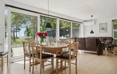 a dining room and living room with a table and chairs at 3 Bedroom Lovely Home In Hurup Thy in Sønder Ydby
