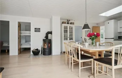 a kitchen and dining room with a table and a fireplace at 3 Bedroom Lovely Home In Hurup Thy in Sønder Ydby