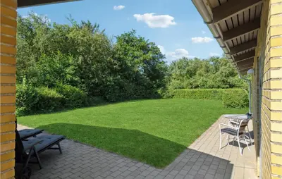 a patio with a lawn with a table and chairs at 3 Bedroom Lovely Home In Hurup Thy in Sønder Ydby
