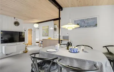 a kitchen and dining room with a table and chairs at 3 Bedroom Lovely Home In Hurup Thy in Sønder Ydby