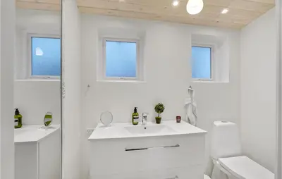 a white bathroom with a sink and a toilet at 3 Bedroom Lovely Home In Hurup Thy in Sønder Ydby