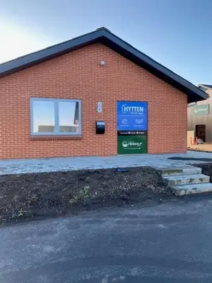 a red brick building with a sign on it at Hytten in Lemvig