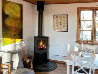 a fireplace in a living room with a table and chairs at 4 person holiday home in Aars-By Traum in Års