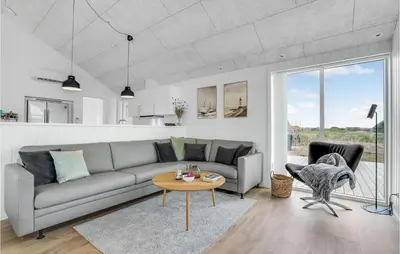 a living room with a couch and a table at Amazing Home In Harboøre With 4 Bedrooms, Sauna & Wifi in Harboør