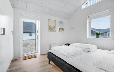 a white bedroom with two beds and a window at Amazing Home In Harboøre With 4 Bedrooms, Sauna & Wifi in Harboør