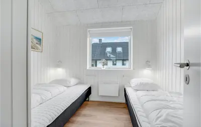two beds in a room with a window at Amazing Home In Harboøre With 4 Bedrooms, Sauna & Wifi in Harboør