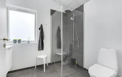 a white bathroom with a shower and a toilet at Amazing Home In Harboøre With 4 Bedrooms, Sauna & Wifi in Harboør