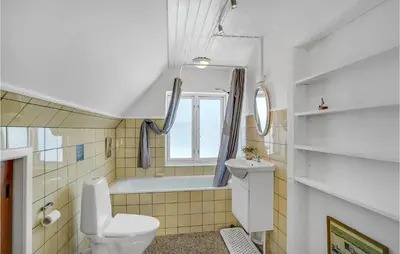 a bathroom with a toilet and a tub and a sink at Lovely Home In Thyborøn With Kitchen in Thyborøn