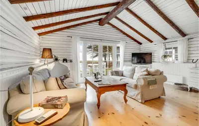 a living room with a couch and a table at 3 Bedroom Cozy Home In Hurup Thy in Sønder Ydby