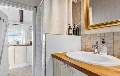 a bathroom with a sink and a mirror at 3 Bedroom Cozy Home In Hurup Thy in Sønder Ydby