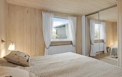 a bedroom with a large bed and a window at Stunning Home In Løkken With Kitchen in Løkken