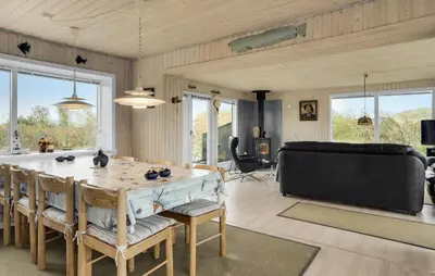 a living room with a large wooden table and chairs at Stunning Home In Løkken With Kitchen in Løkken