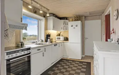 a kitchen with white appliances and a large window at Stunning Home In Løkken With Kitchen in Løkken