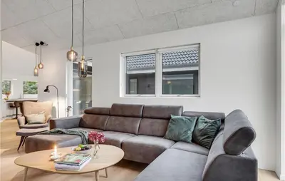 a living room with a couch and a table at Gorgeous Home In Blokhus With Jacuzzi in Blokhus