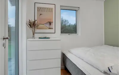 a white bedroom with a bed and a window at Gorgeous Home In Blokhus With Jacuzzi in Blokhus