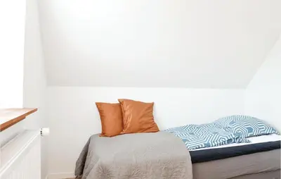 a bed with orange pillows on top of it at Cozy Home In Lemvig With Wifi in Lemvig