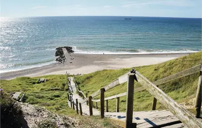 a beach with a wooden fence next to the ocean at Cozy Home In Lemvig With Wifi in Lemvig