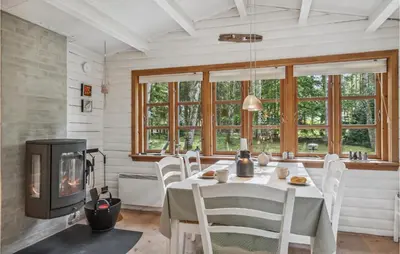 a dining room with a table and a fireplace at Holiday Home Jelsevej Ix in Højslev