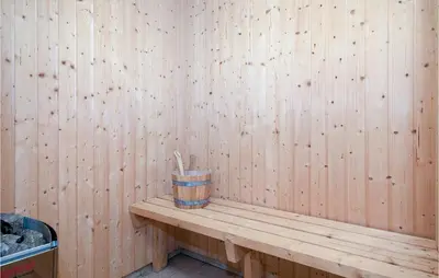 a wooden bench with a cup on top of it at Holiday Home Egebækvej in Blokhus