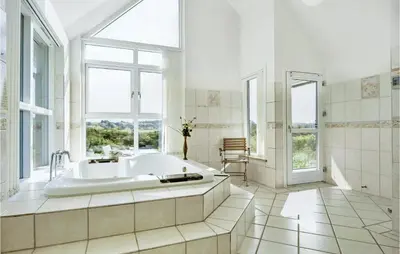 a large bathroom with a tub and a window at Holiday Home Ved Stranden in Blokhus