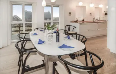 a dining room with a white table and chairs at Holiday Home Ved Stranden in Blokhus