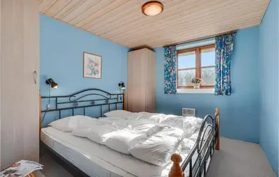 a bedroom with a bed with blue walls and a window at Holiday Home Strandlyst Vinderup Iv in Vinderup