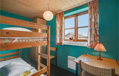 a bedroom with two bunk beds and a desk and a window at Holiday Home Strandlyst Vinderup Iv in Vinderup