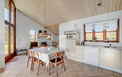 a kitchen and dining room with a table and chairs at Holiday Home Strandlyst Vinderup Iv in Vinderup