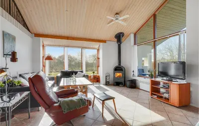 a living room with a couch and a table and a tv at Holiday Home Strandlyst Vinderup Iv in Vinderup