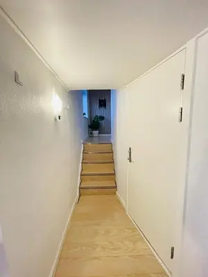a hallway with white walls and wooden floors and a staircase at aday - 3 bedrooms luxurious apartment in Svenstrup in Svenstrup