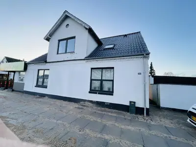 a white house with a black roof at aday - 3 bedrooms luxurious apartment in Svenstrup in Svenstrup
