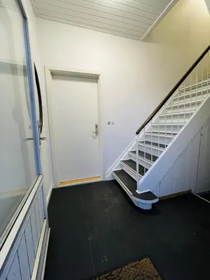 an empty hallway with a white door and stairs at aday - 3 bedrooms luxurious apartment in Svenstrup in Svenstrup